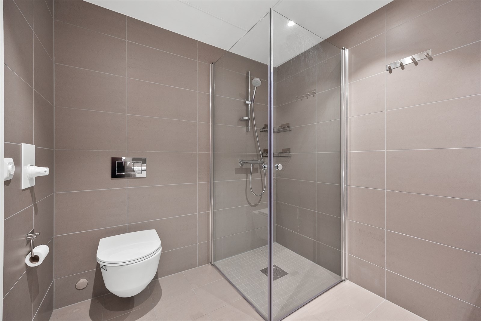 Dusjhjørnet er praktisk utformet, og badet har vegghengt toalett for enklere renhold. Galleribilde
