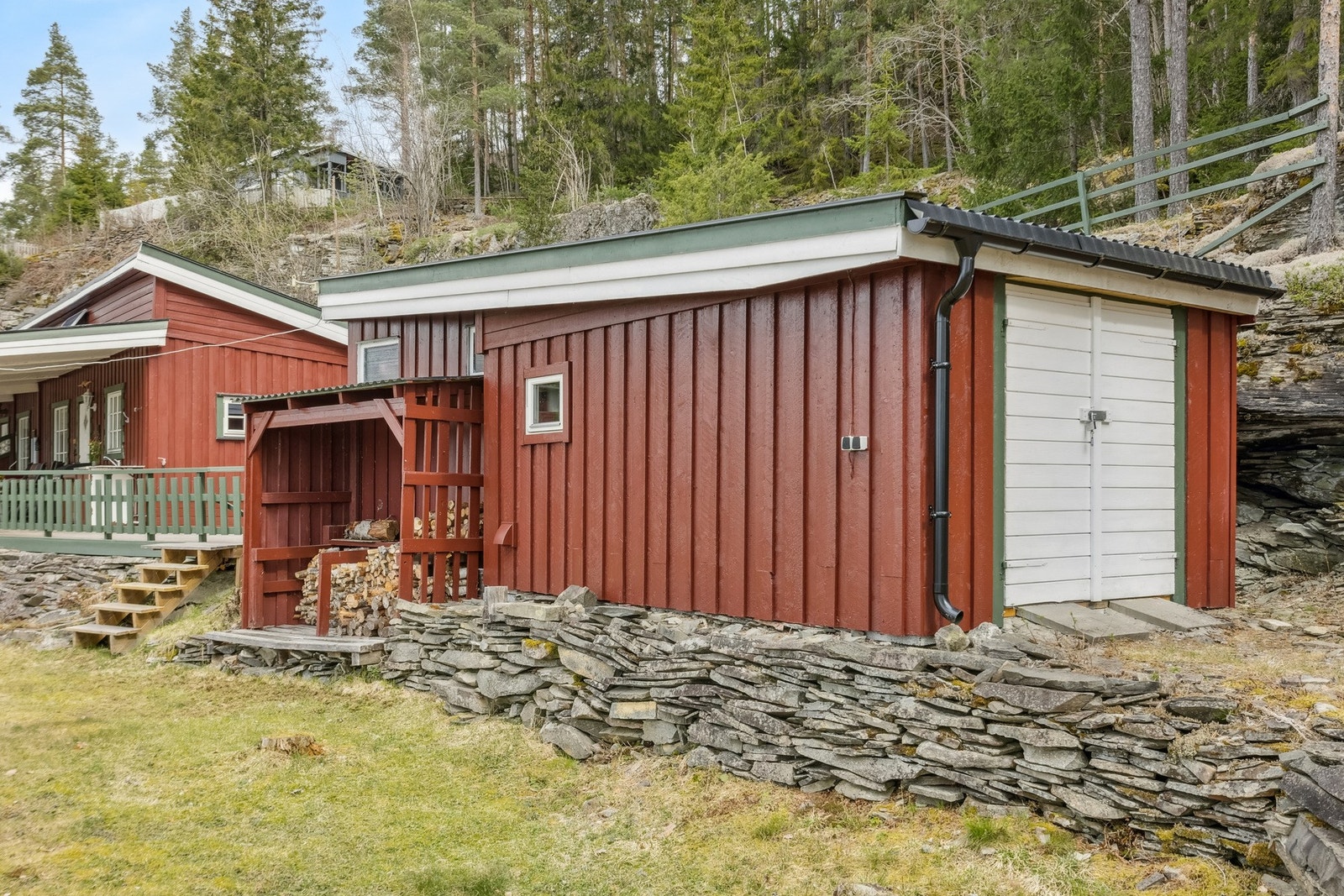 Den store uteboden har god plass innvendig og vedskjul utenfor Galleribilde