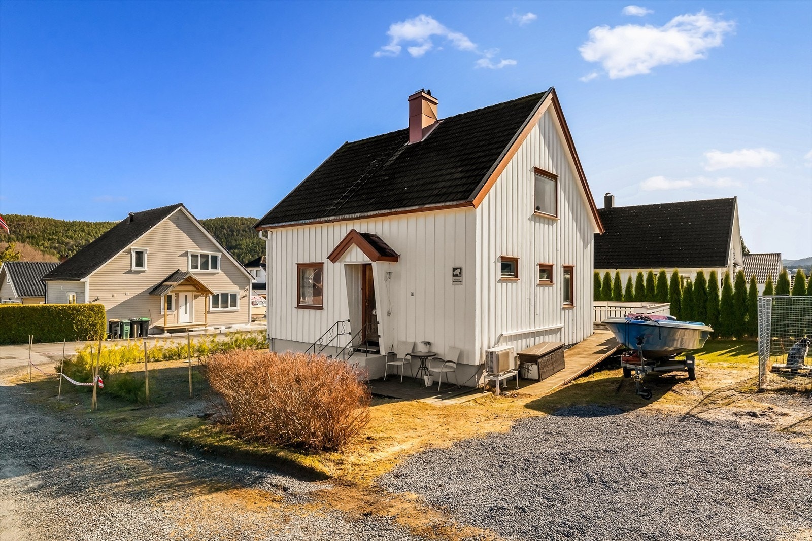 Tomten er opparbeidet med hekk mot nabo og veien. Gruset parkering i tillegg til garasje. Galleribilde