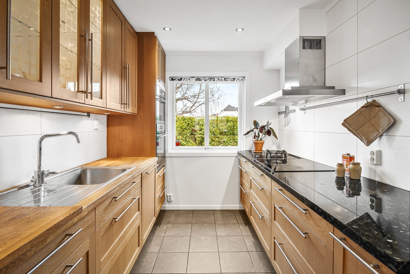 Kjøkkeninnredning med profilerte fronter og benkeplater av naturstein og laminert heltre Galleribilde