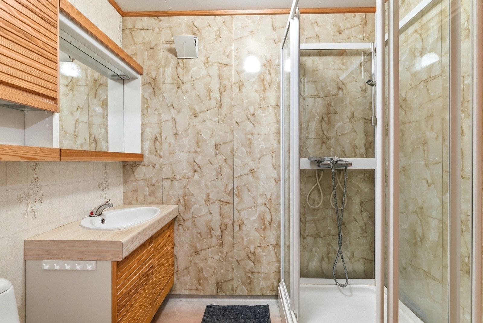 Det er vinylbelegg med elektriske varmekabler og dusjkabinett. Galleribilde