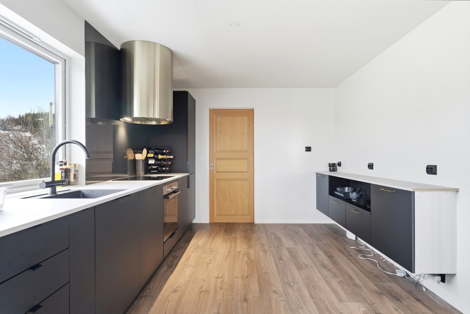 Det er lys benkeplate og servant i sort utførelse, ventilatoren bidrar til å sette et mer detaljert preg på rommet med en kald gullfarge. Galleribilde