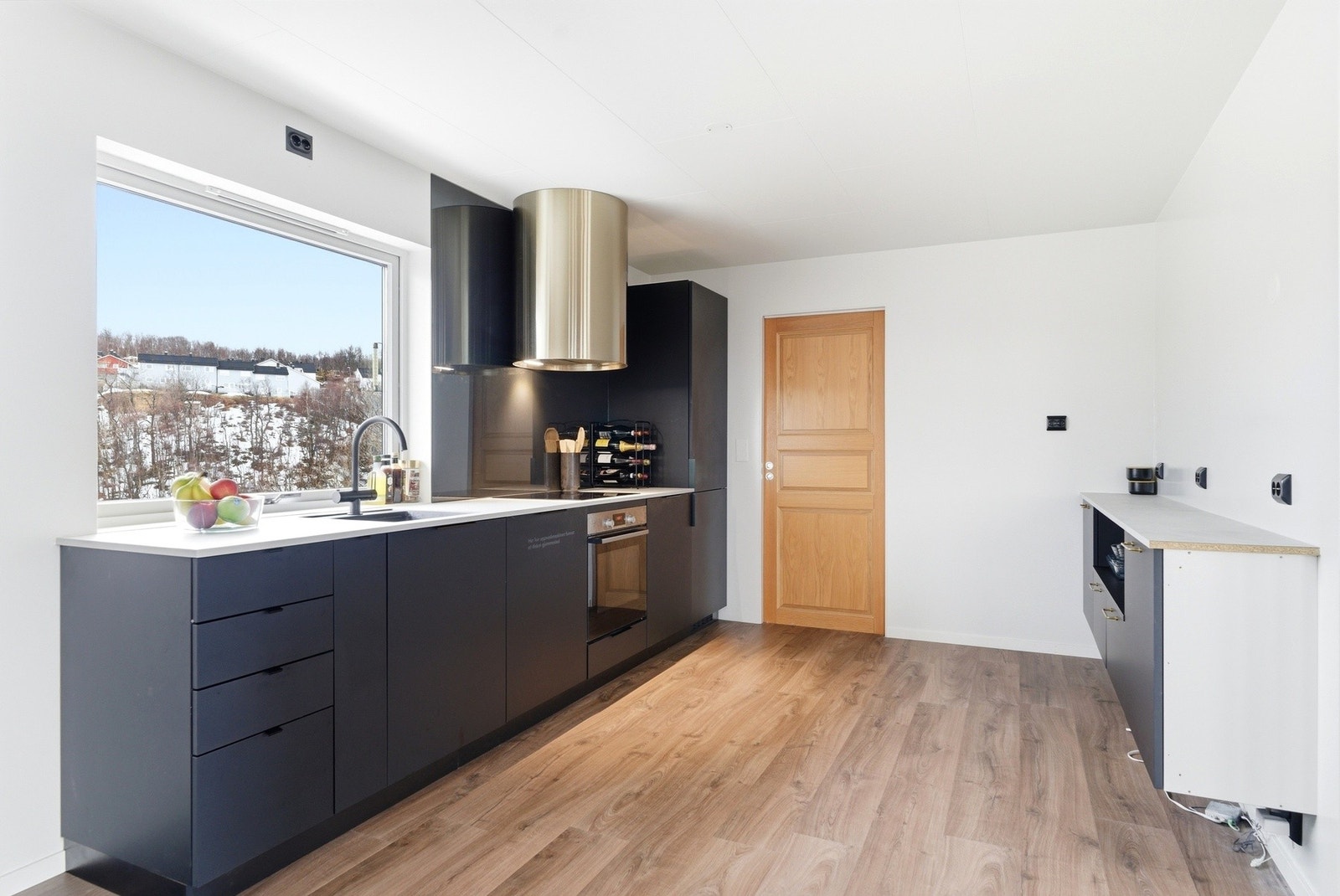 Kjøkkenet har integrerte hvitevarer med komfyr, oppvaskmaskin og kjøleskap. Galleribilde