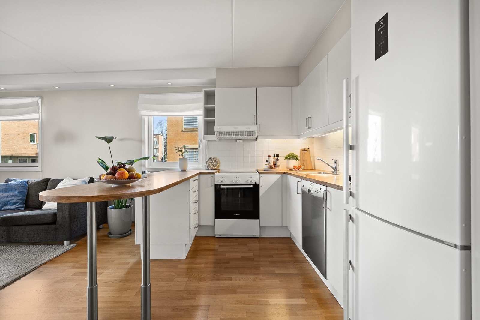 Kjøkkeninnredning med glatte fronter, benkeplate i laminat og installert komfyrvakt for ekstra sikkerhet. Galleribilde