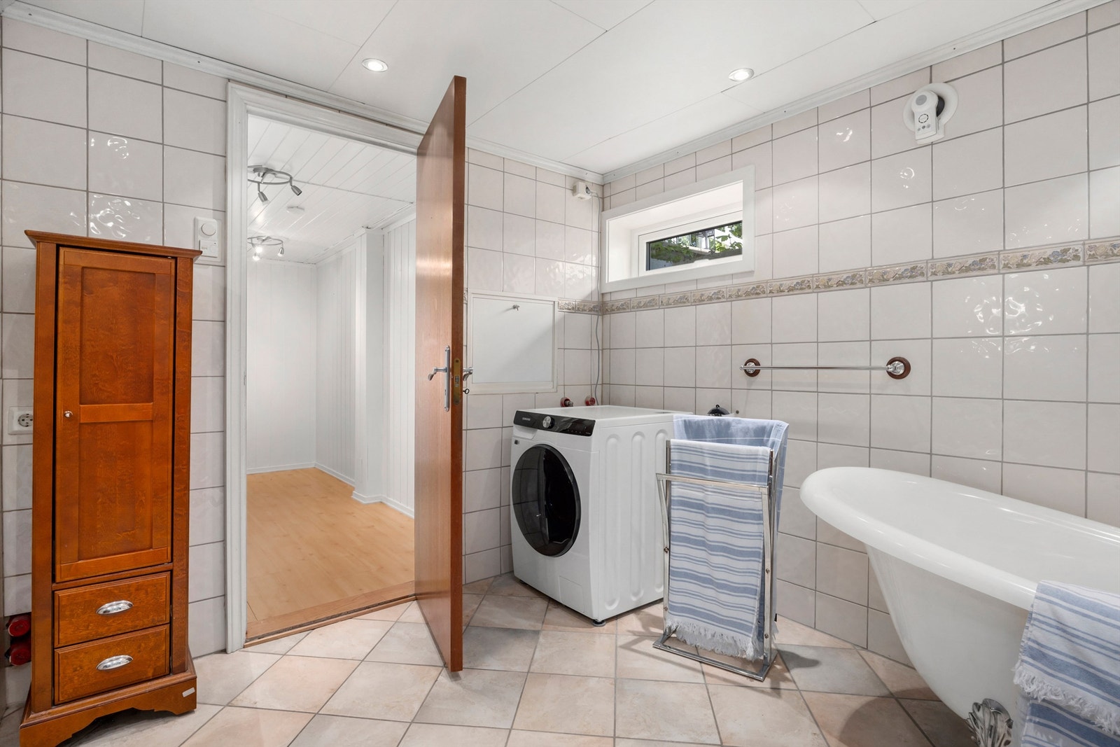 Romslig bad med badekar og opplegg for vaskemaskin. Galleribilde