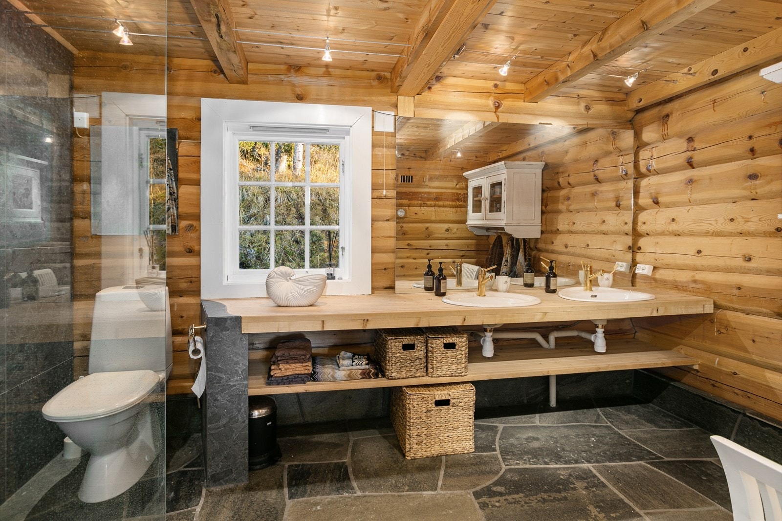 Badet ble oppgradert i 2021 og har bruddskifer på gulv med varmekabler, oppmurt benkeplate med dobbel servant, walk-in-shower og toalett. Galleribilde