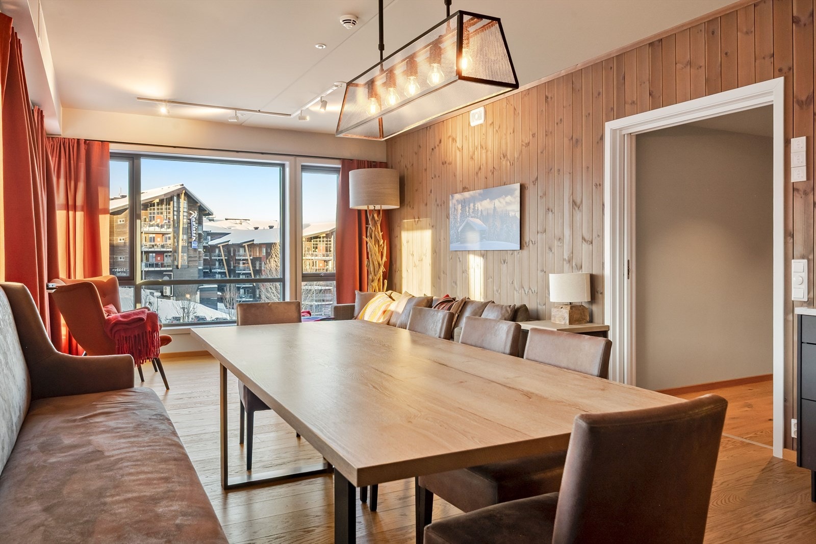 Gulv i stue og spiseplass er dekket med parkett, mens veggene er utført med trepanel. Galleribilde