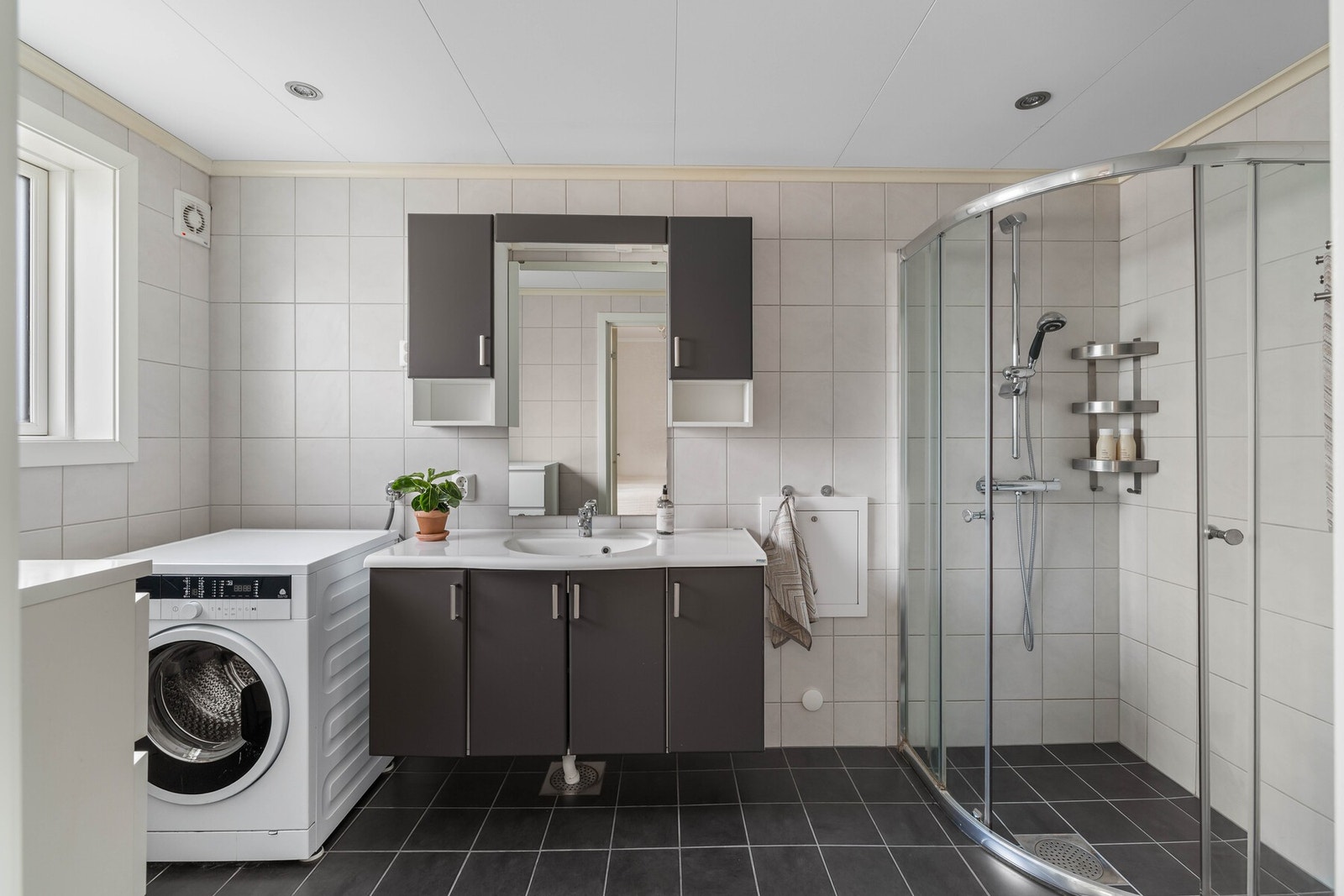 Badet ble pusset opp i 2014, og ligger i tilknytning til hovedsoverommet. Lysegrå veggfliser kombineres med mørkere gulvfliser, og badet har downlights, varmekabler og et dusjhjørne med skyvedører. Galleribilde