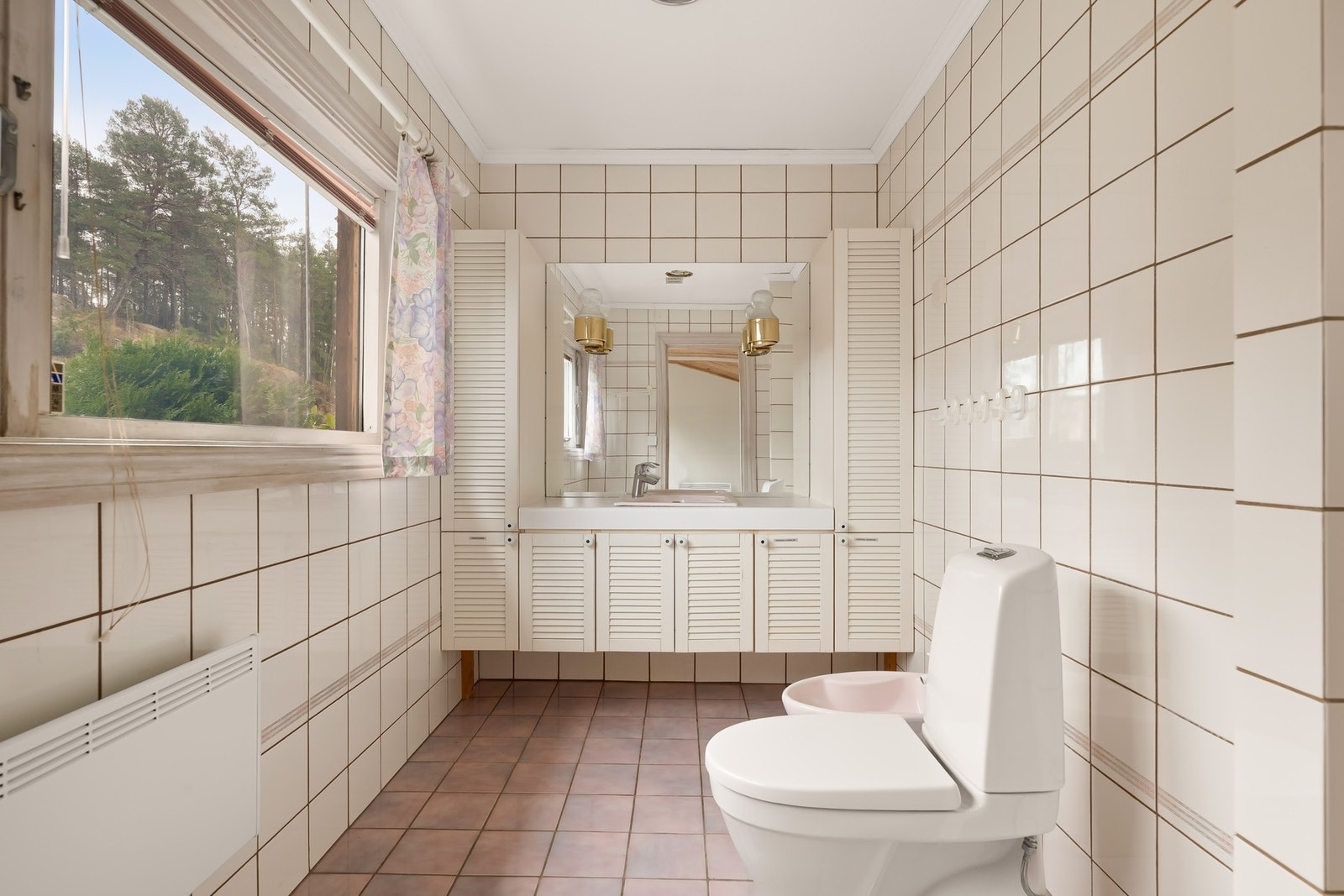 Baderommet er flislagt og er innredet med dusjnisje, bide, gulvstående wc, servantskap med vask Galleribilde