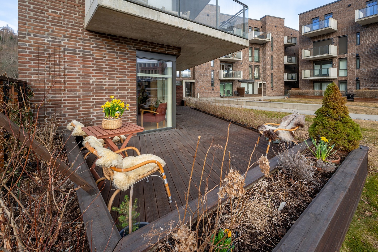 Både hekk og blomsterbed skjermer terrassen bra på sommerstid. Galleribilde