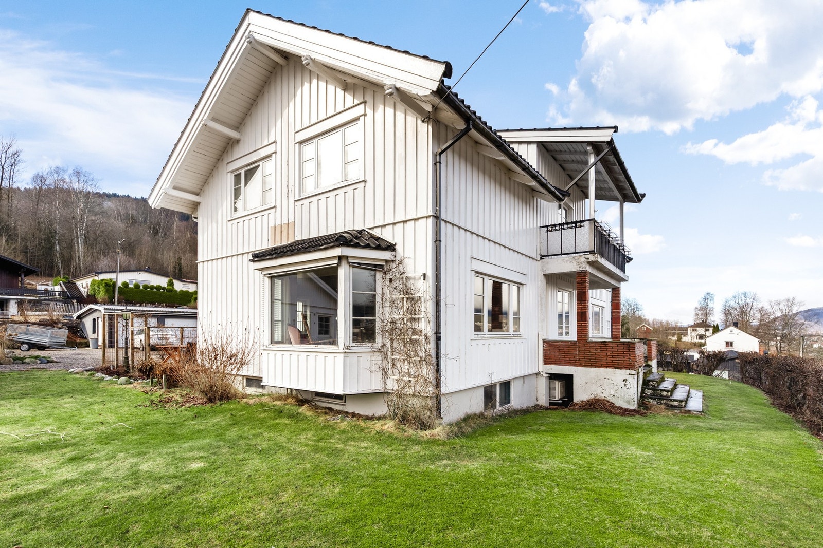 Tomten er pent opparbeidet med bl.a. gruslagt gårdsplass, plenarealer og diverse beplantninger Galleribilde