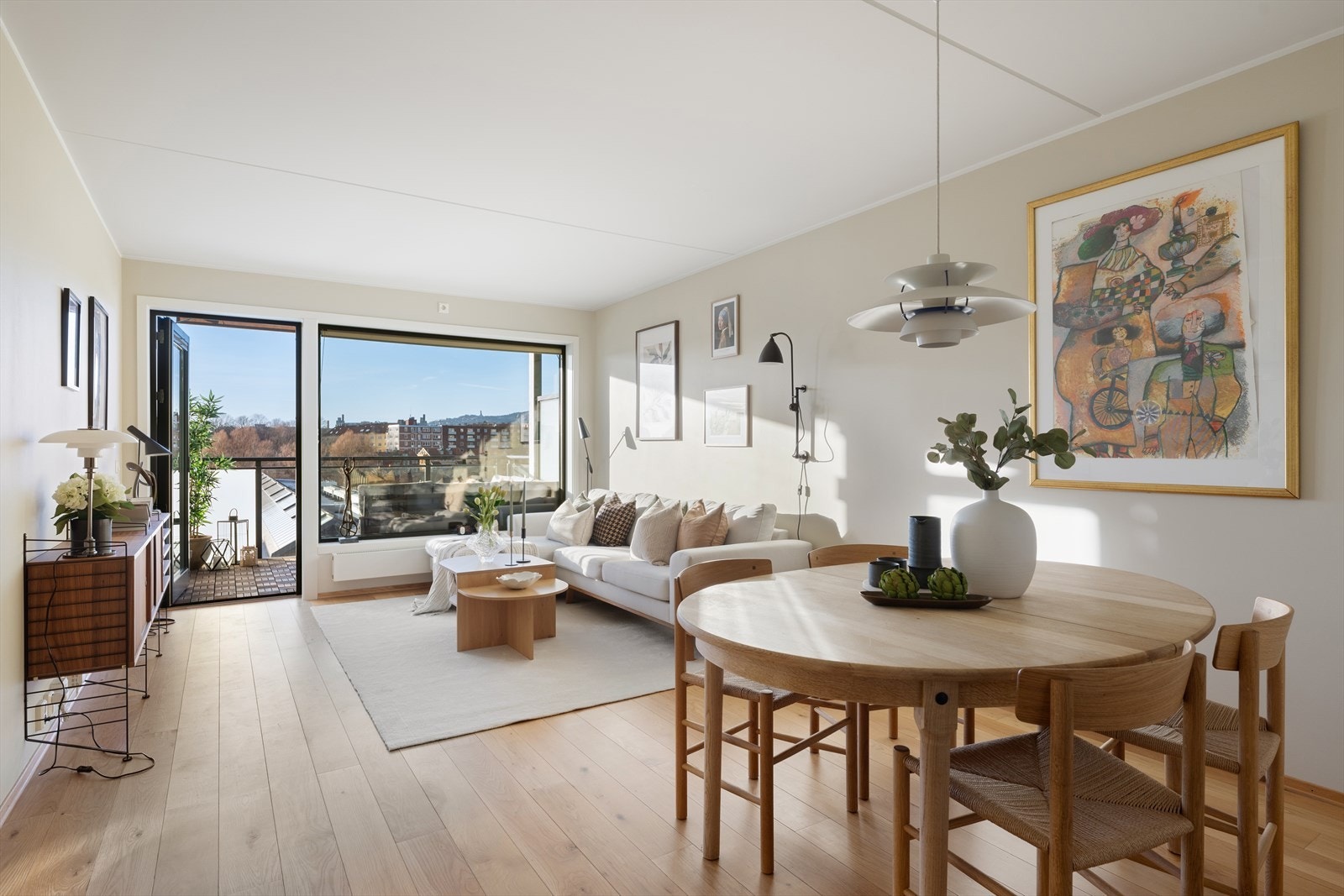 Dagslyset flommer inn gjennom den store glassfasaden, samtidig som den upåklagelige utsikten mot Holmenkollen flyter sømløst inn i rommet og blir en naturlig del av interiøret Galleribilde