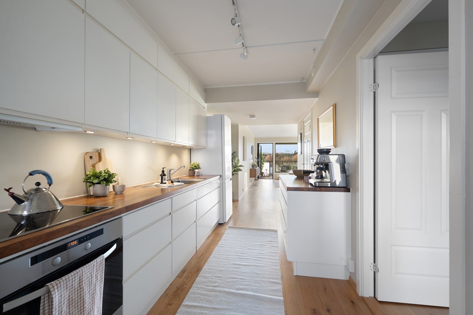 Selv om det utsøkte kjøkkenet ligger tilbaketrukket fra stuen, kan samtalen flyte fritt selv under middagsforberedelsene Galleribilde