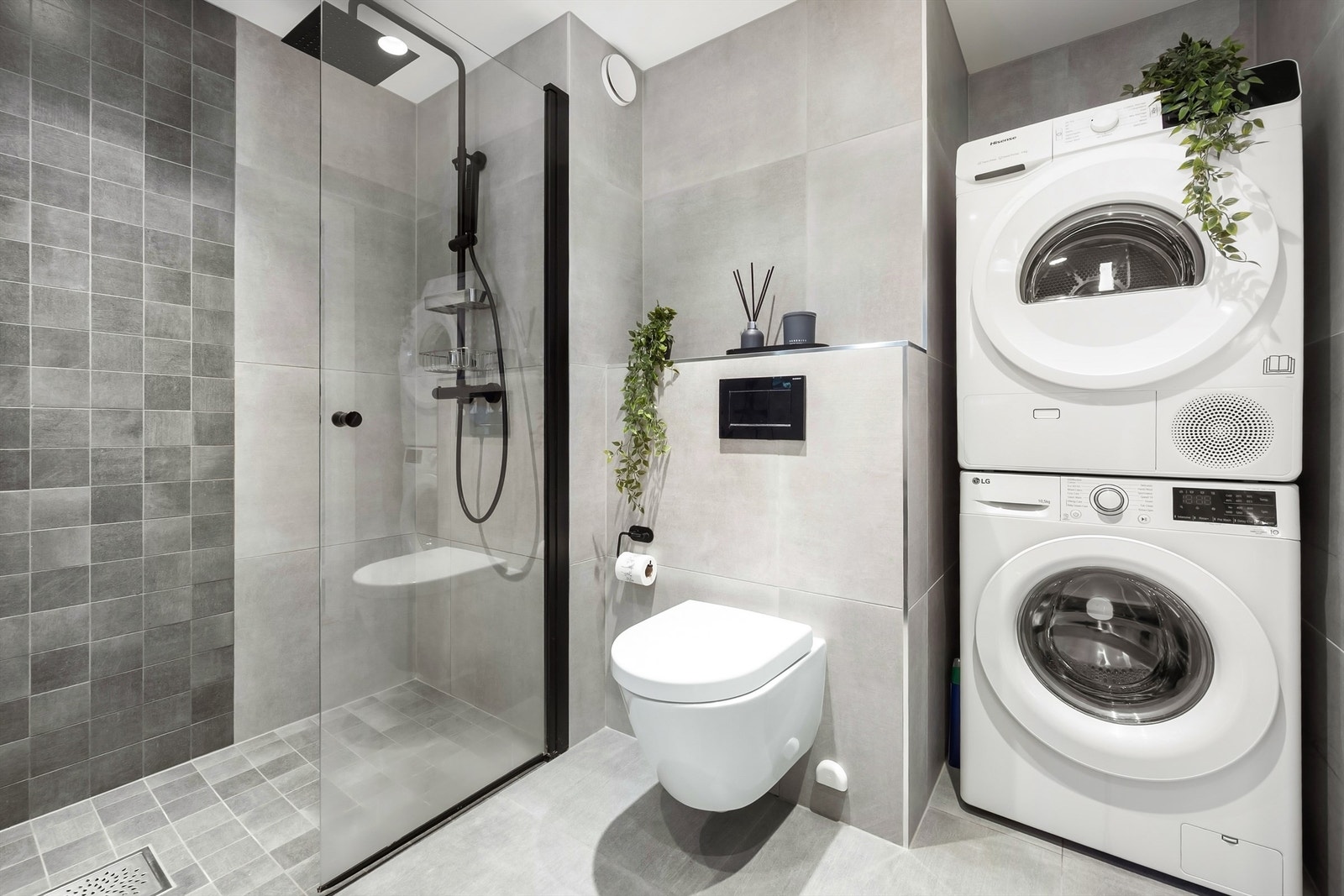 Badet har praktisk opplegg for vaskemaskin og tørketrommel i søyle. Galleribilde