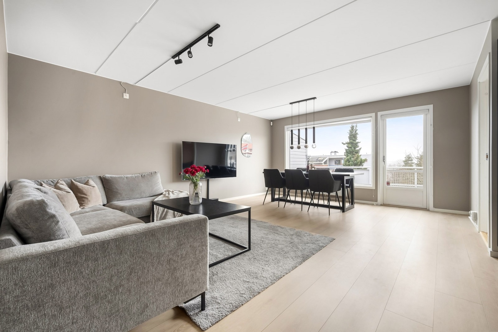 Leiligheten har en åpen og sosial planløsning mellom stue og kjøkken, med gjennomgående gulv som binder rommene sammen. Galleribilde