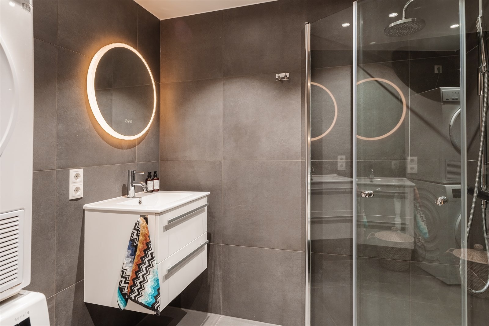 Videre er badet utstyrt med servant med skuffeinnredning, samt vegghengt klosett med innebygget sisterne. Det er også opplegg for vaskemaskin Galleribilde