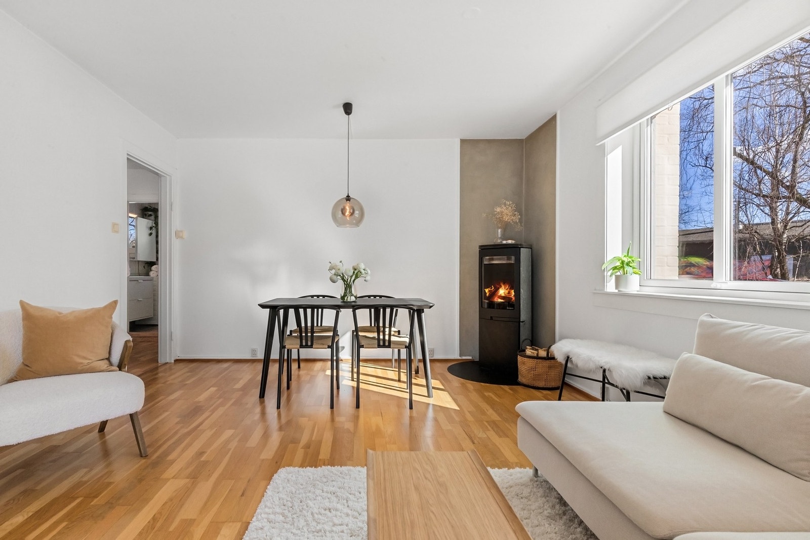Her er det god plass til både sofagruppe og spisebord, og den hyggelige peisovnen skaper en lun atmosfære på vinterhalvåret Galleribilde