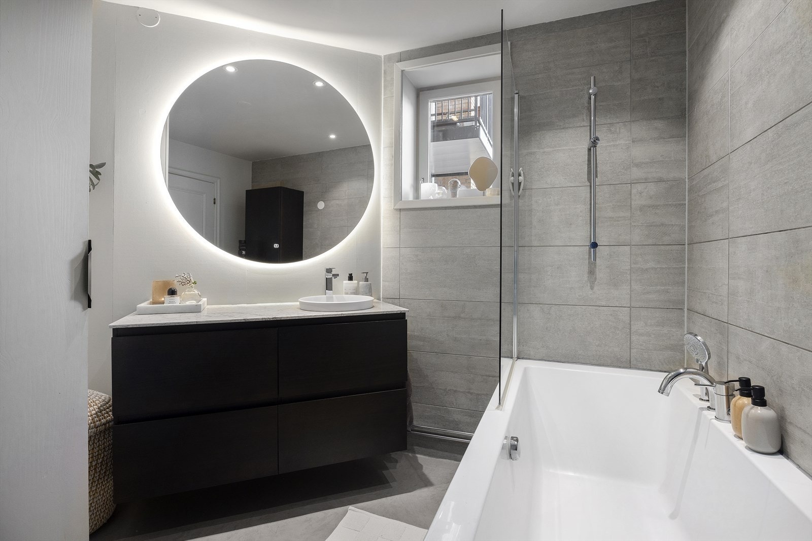 Badet er innredet med badekar, servantmøbel og nydelig speil Galleribilde