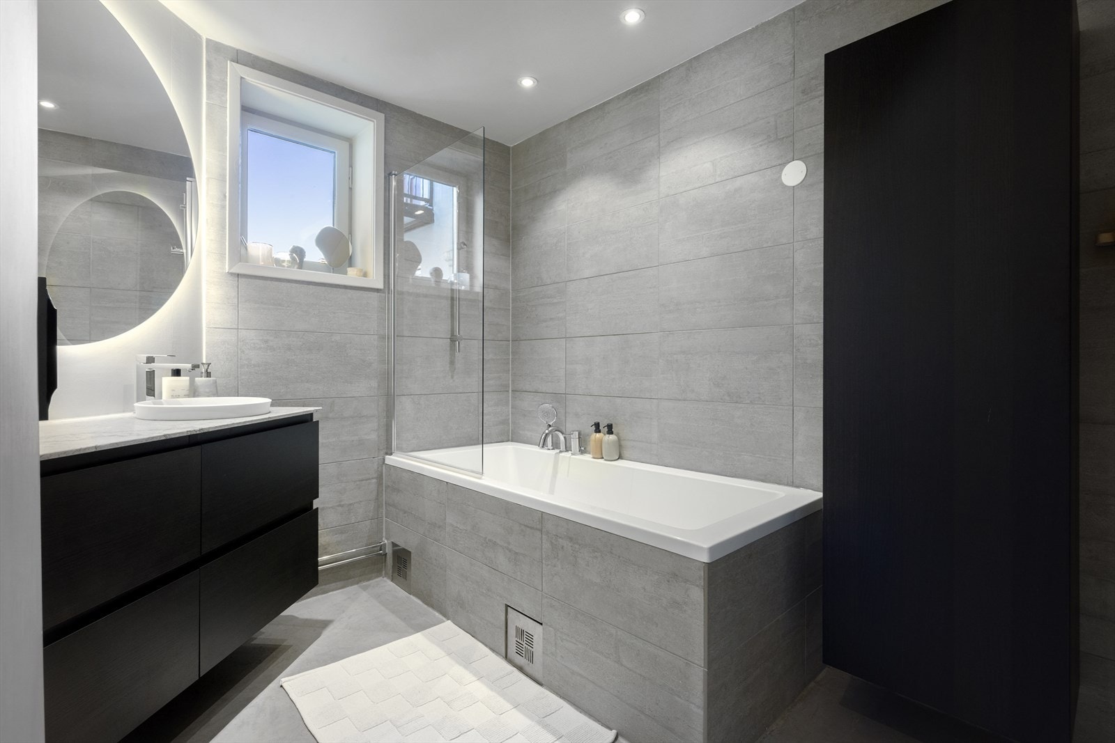 Lekkert bad med fliser på vegger, mikrosement på gulv og elektriske varmekabler. Overflateoppusset 2017, byttet innredning i 2023 Galleribilde