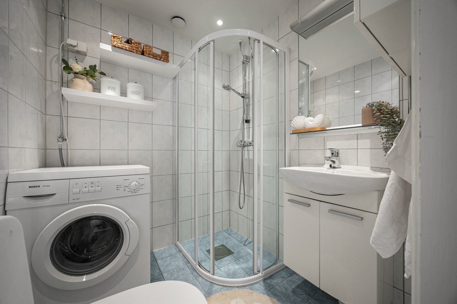 Innredningen består av servantskap med ettgreps blandebatteri, speil med tilhørende belysning, veggskap, gulvstående toalett og dusjkabinett med glassfronter, blandebatteri og dusjgarnityr. Det er også opplegg for vaskemaskin. Galleribilde