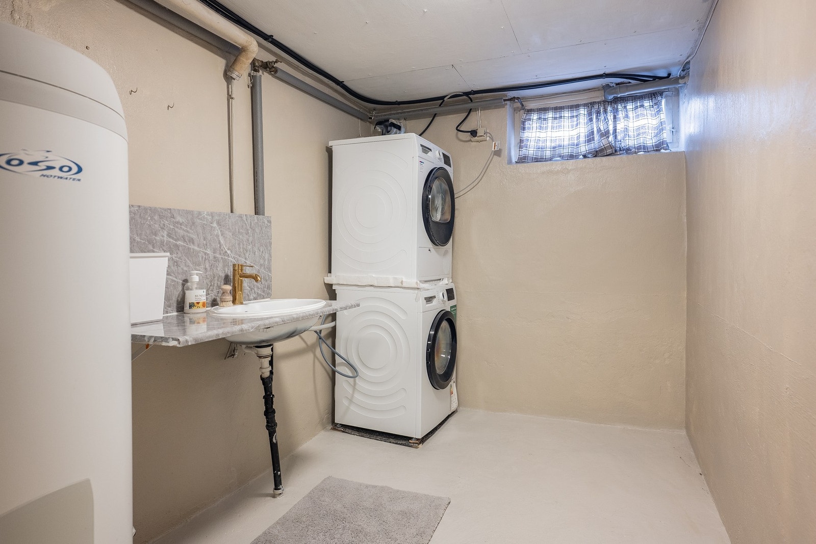 Uinnredet kjeller med tre boder og teknisk rom med bereder, skyllekum og opplegg for vaskemaskin. Galleribilde