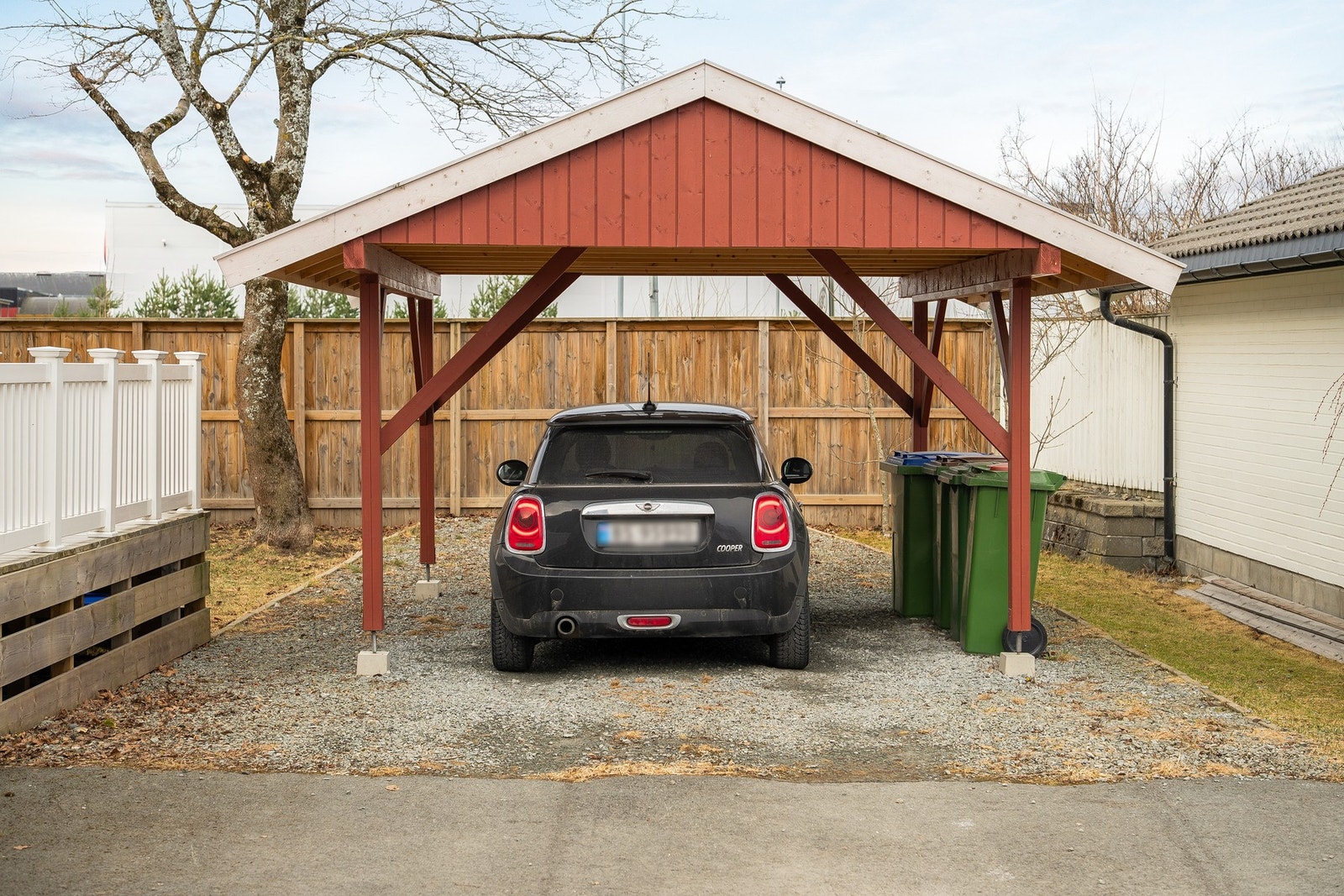 Asfaltert gårdsplass og parkering i carport. Galleribilde