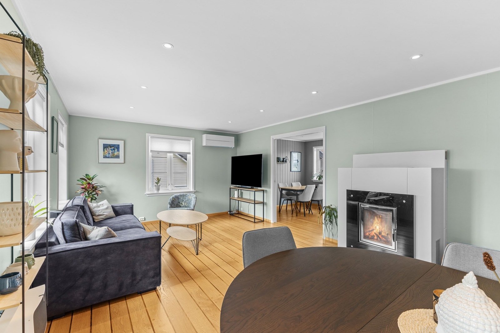 Stue i hovedplan med peisovn og varmepumpe Galleribilde