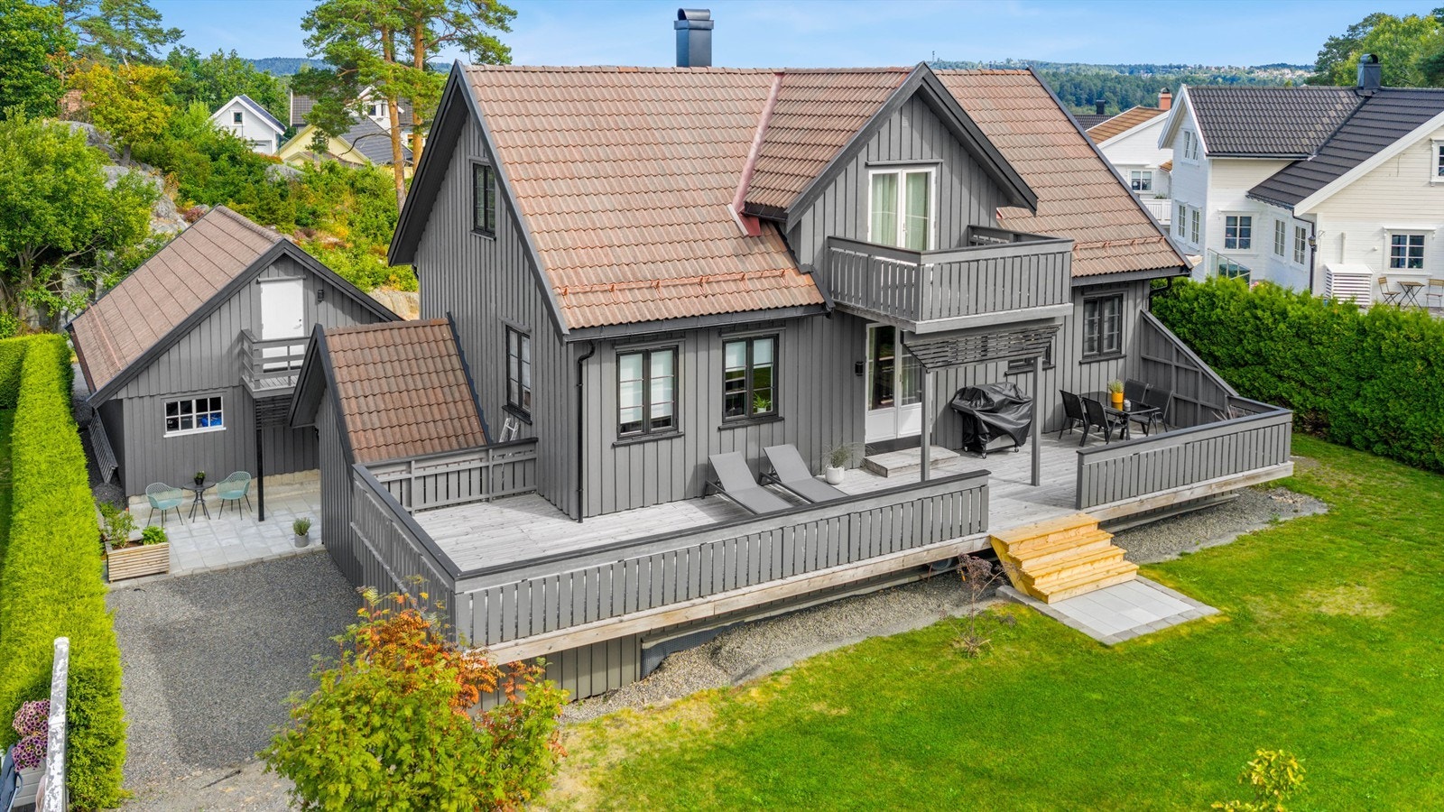 Koselig hage med flere fine uteplasser rundt boligen Galleribilde