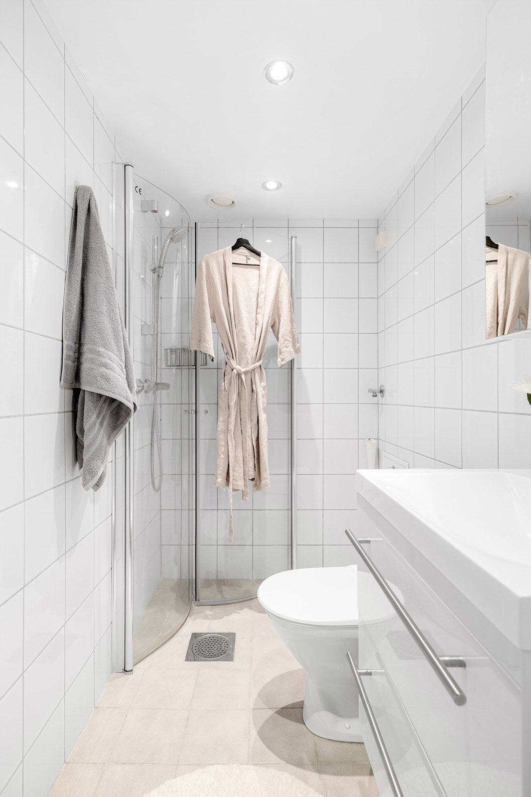 Badet er innredet med dusjhjørne, servant på servantskap og toalett. Galleribilde