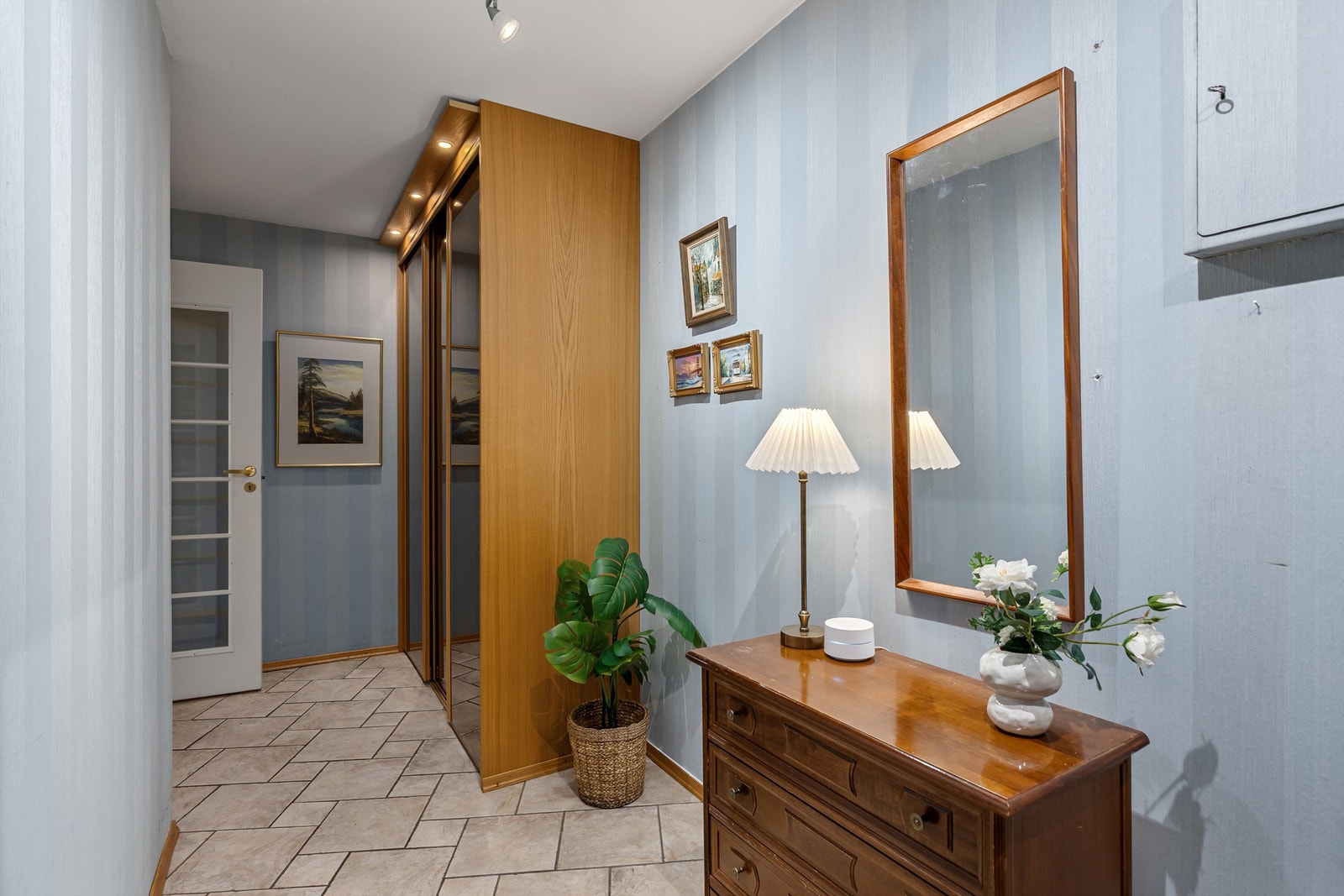 Entré med flislagt gulv med gulvvarme og medfølgende skyvedørsgarderobe Galleribilde