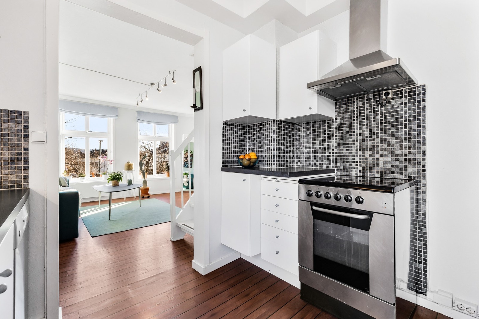 Kjøkken med hvite fronter og mørk benkeplate. Galleribilde