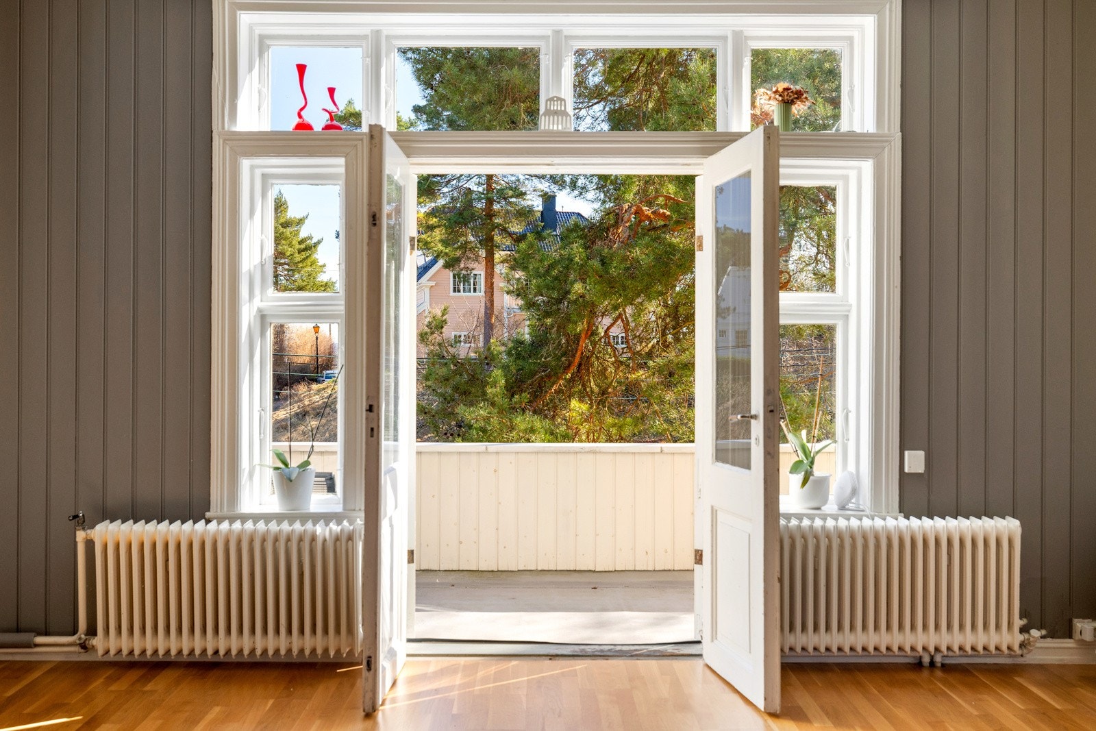 En tofløyet balkongdør innrammet av klassiske vinduer, gir rommet godt med naturlig lys. Galleribilde