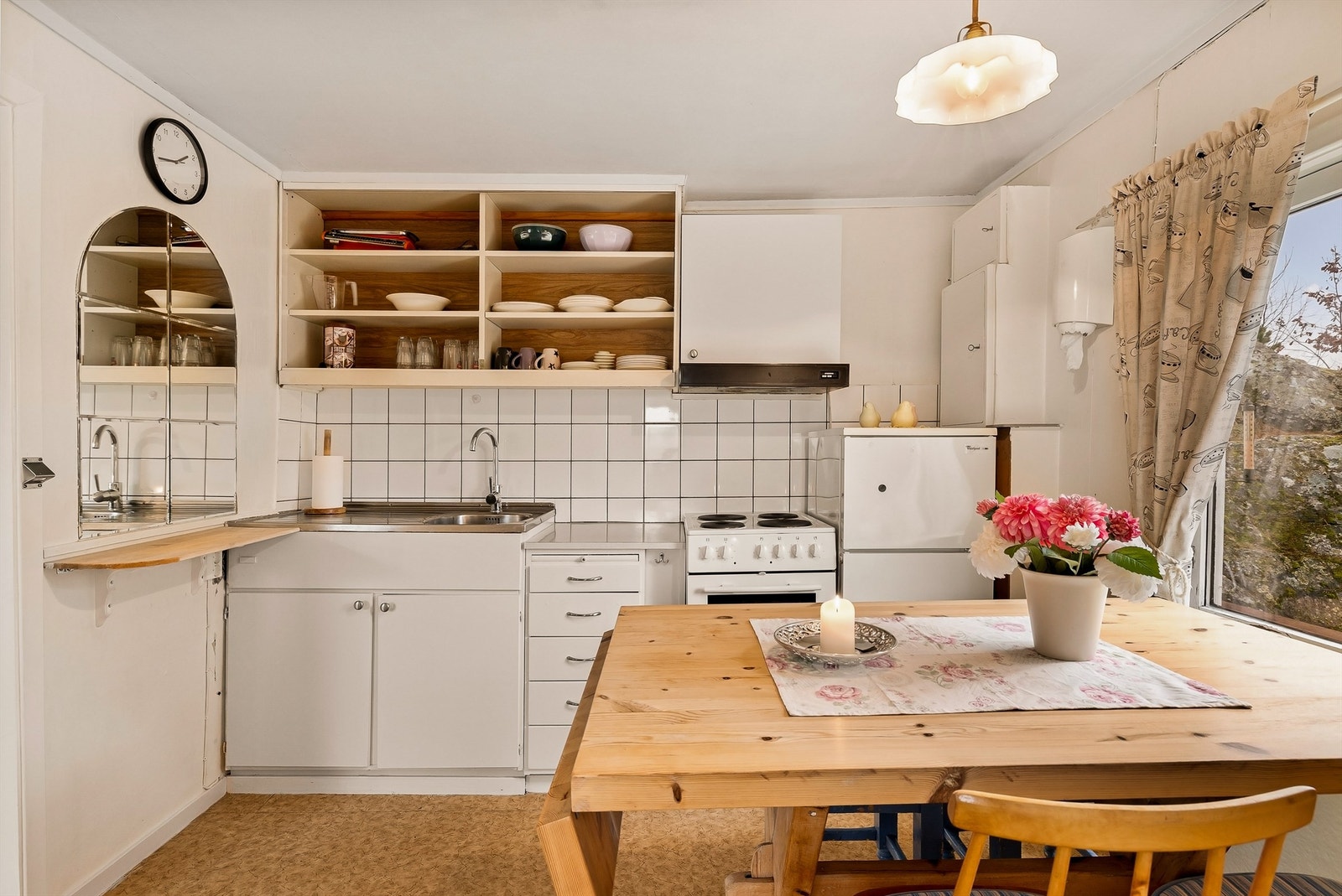 På kjøkkenet er det også plass til spisebord. Innredningen er enkel med malte fronter og åpne hyller istedenfor overskap. Galleribilde