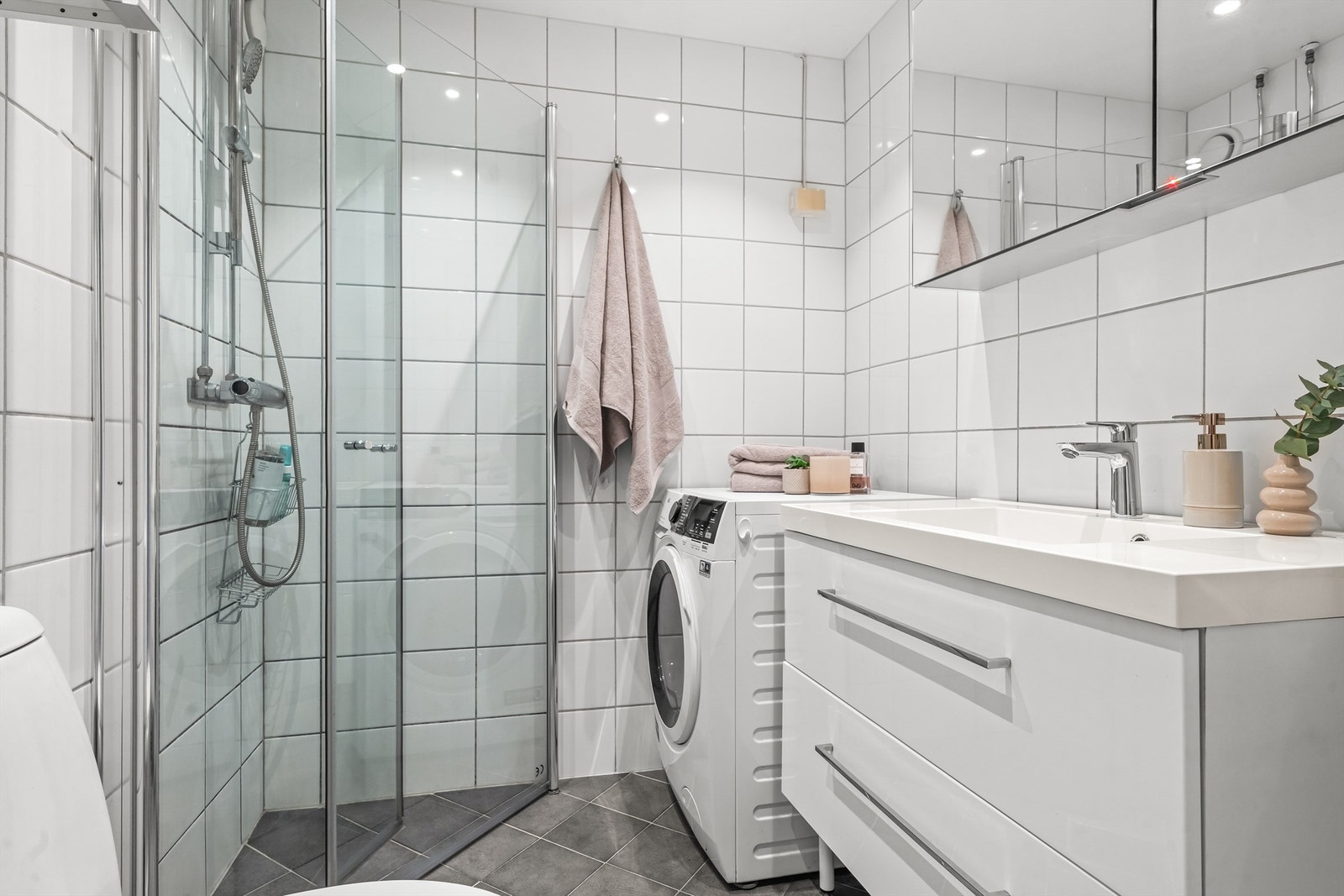 Baderomsinnredning med god oppbevaringsplass i skuffer og overskap. Galleribilde