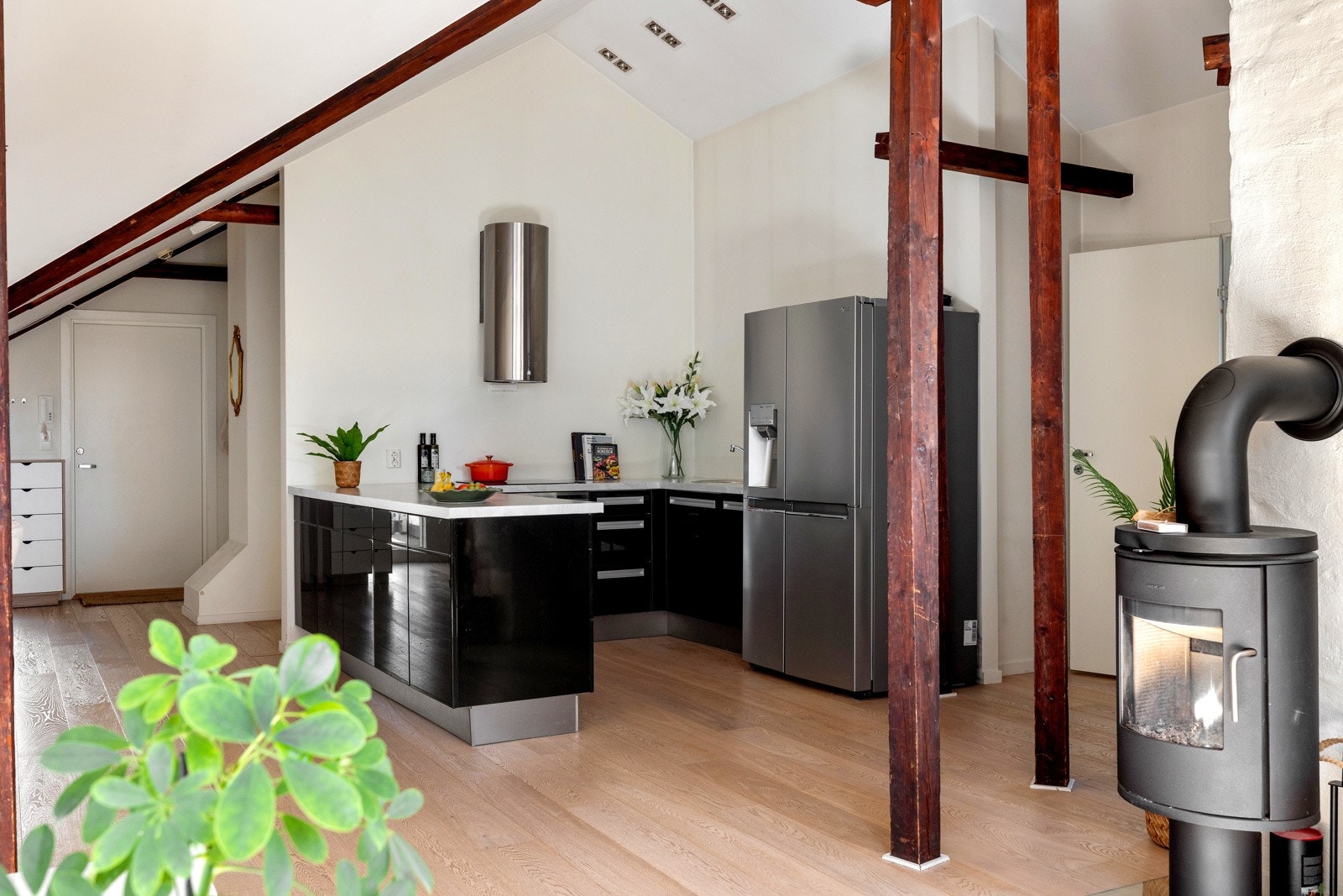 Kjøkkenet har en moderne utforming med sorte høyglansfronter og benkeplate i en stilren utførelse. Galleribilde