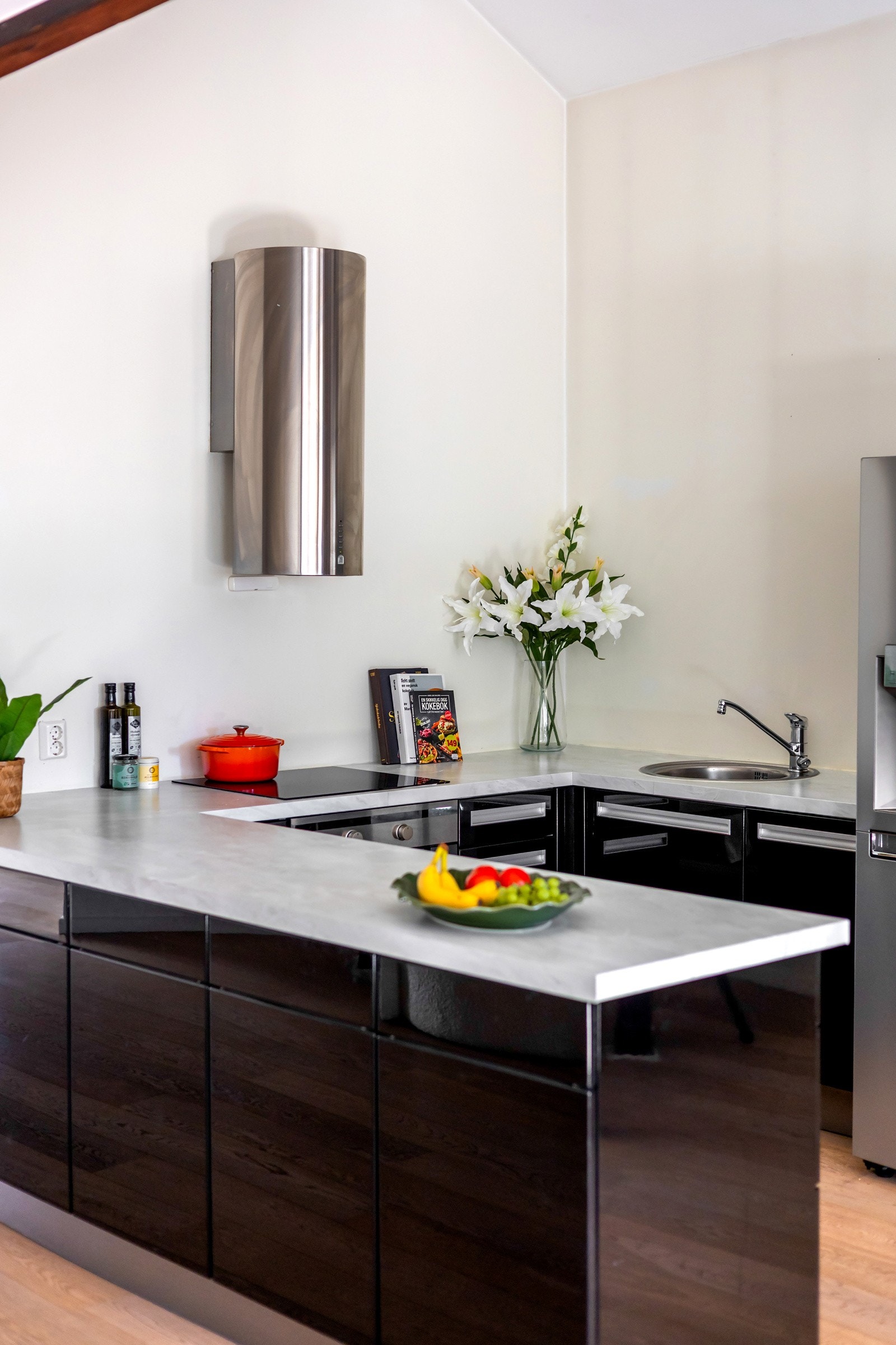 En praktisk barløsning binder kjøkkenet sømløst sammen med stuen og gjør rommet ideelt for både matlaging og sosiale sammenkomster. Galleribilde