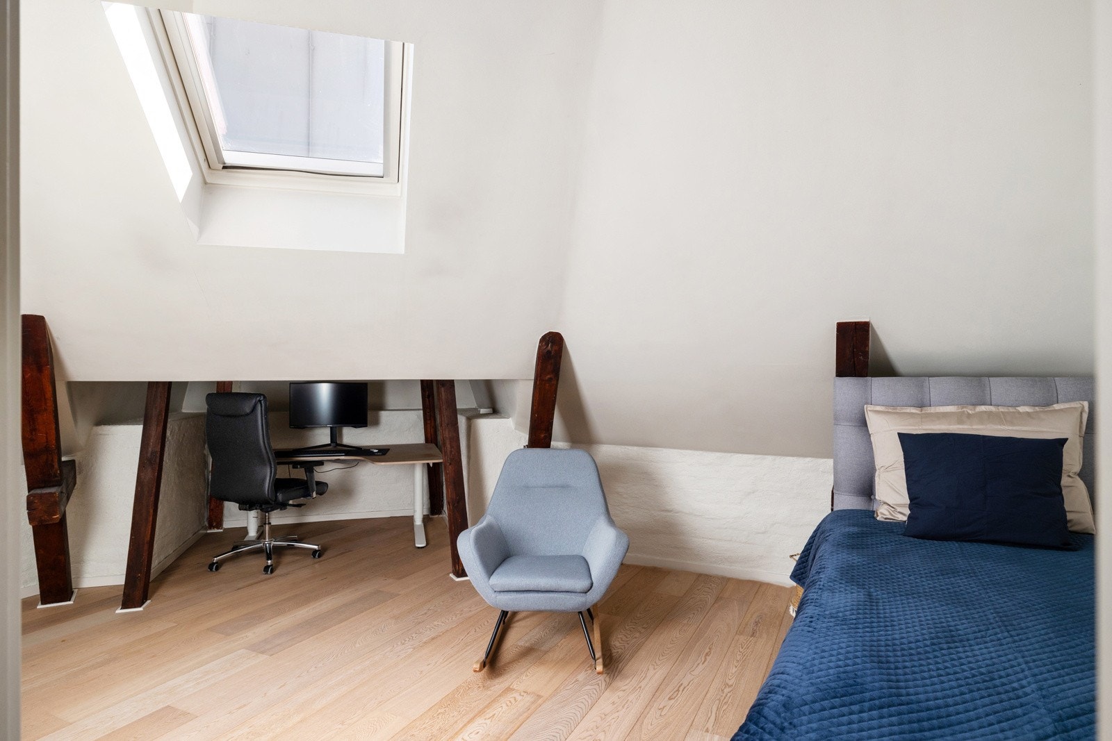 Det største soverommet har en luftig atmosfære med skråtak, synlige trebjelker og et takvindu som slipper inn godt med naturlig lys. Galleribilde