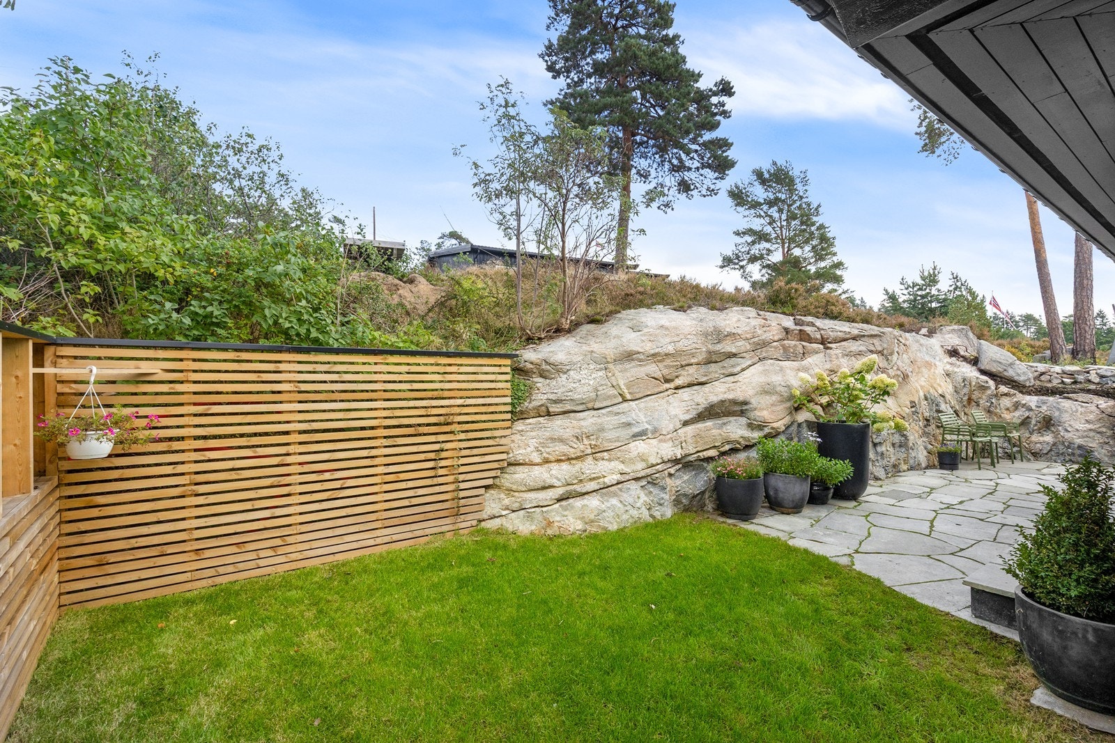 Hage og skiferplatting på østsiden av huset. Galleribilde
