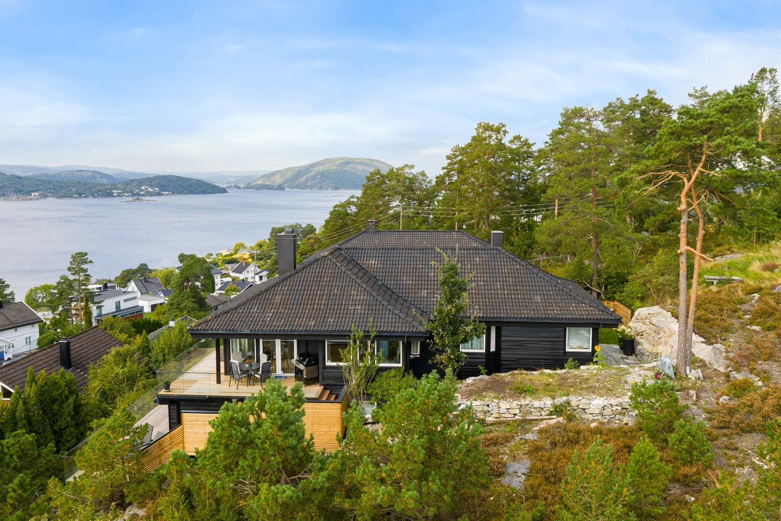 Fasaden sett fra syd. Pent opparbeidet tomt og store terrasseflater i flere nivåer. Galleribilde