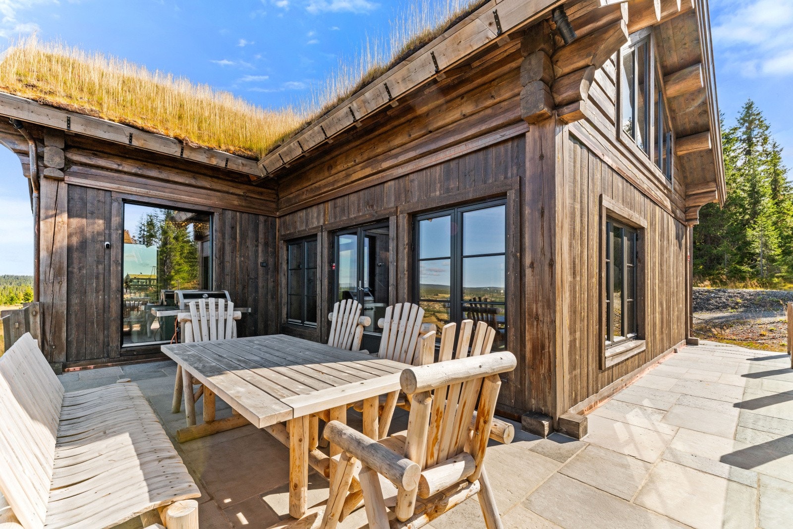 En stor og meget solrik terrasse omkranser hytta mot syd og vest - fantastisk utsikt fra hele terrassen og praktisk adkomst også via gårdsplass Galleribilde