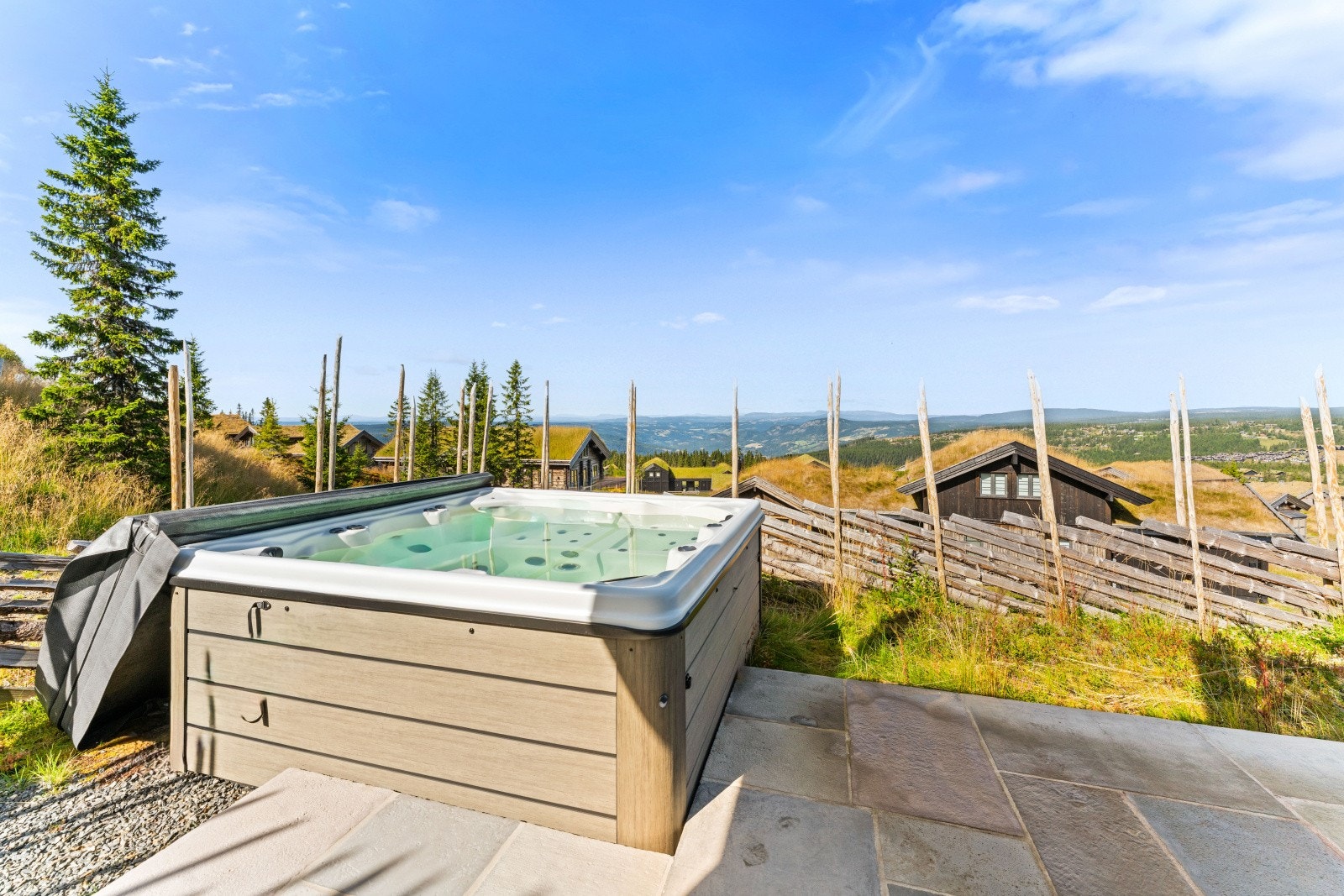 På nedre plan av tomten rundt hytta finnes en romslig ekstra markterrasse inkludert jacuzzi - herlig utsikt også herfra! Galleribilde