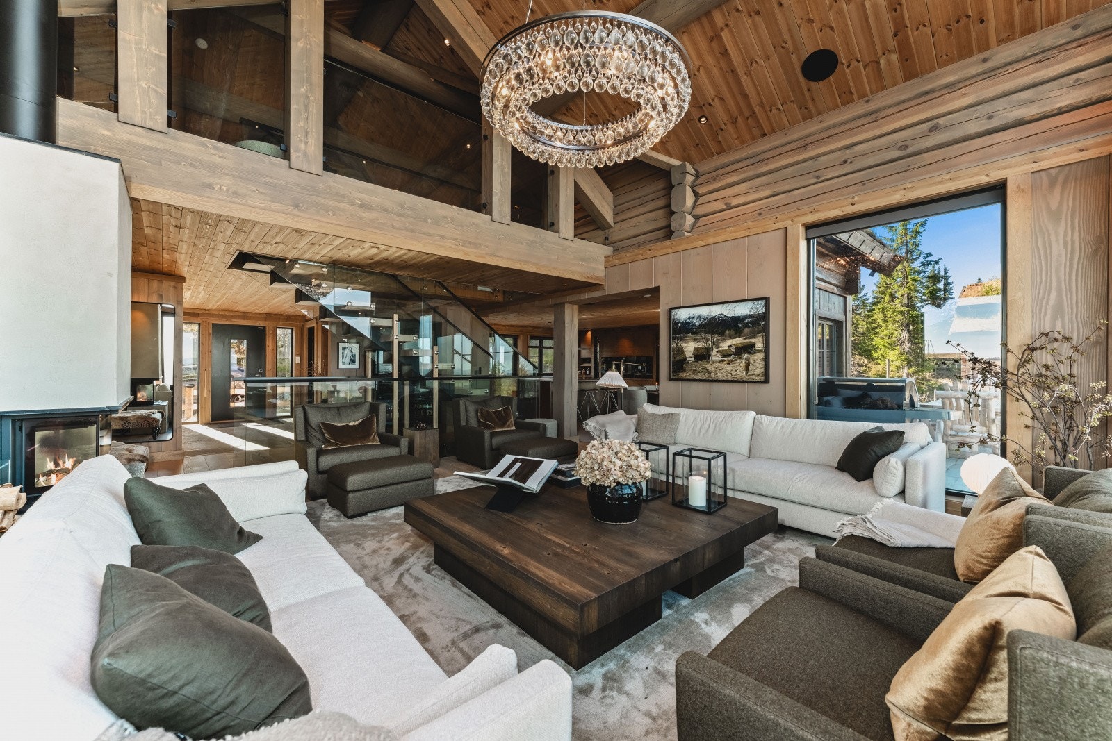 Glasstrappen som skiller hallen mot stuen utgjør et møbel i seg selv og gir gjennomlys tvers gjennom hytta Galleribilde