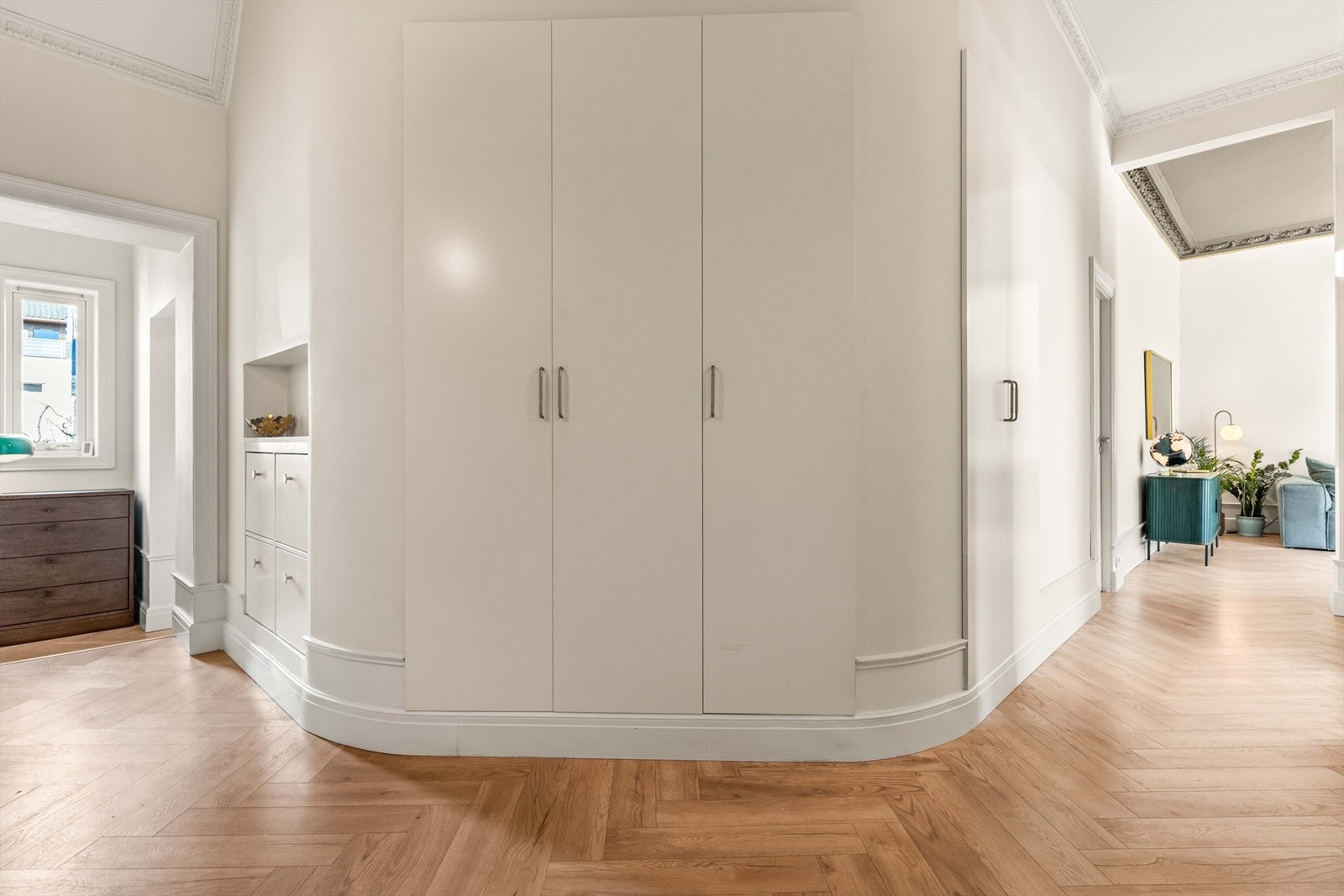 Velkommen inn. Entréen har skreddersydde skapløsninger integrert i en buet vegg, som gir rikelig med oppbevaring. Galleribilde