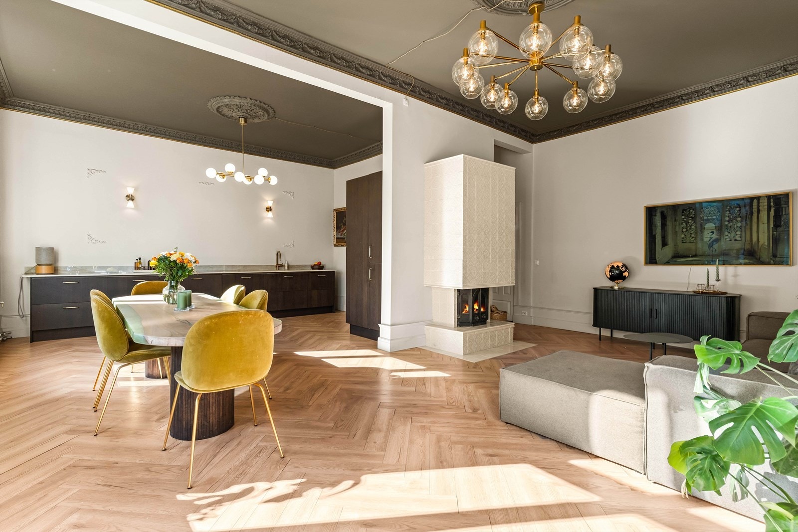 Den åpne stue- og kjøkkenløsningen er et sosialt og innbydende rom. Midt i rommet står ildstedet med nydelig omramming fra 2025. Galleribilde