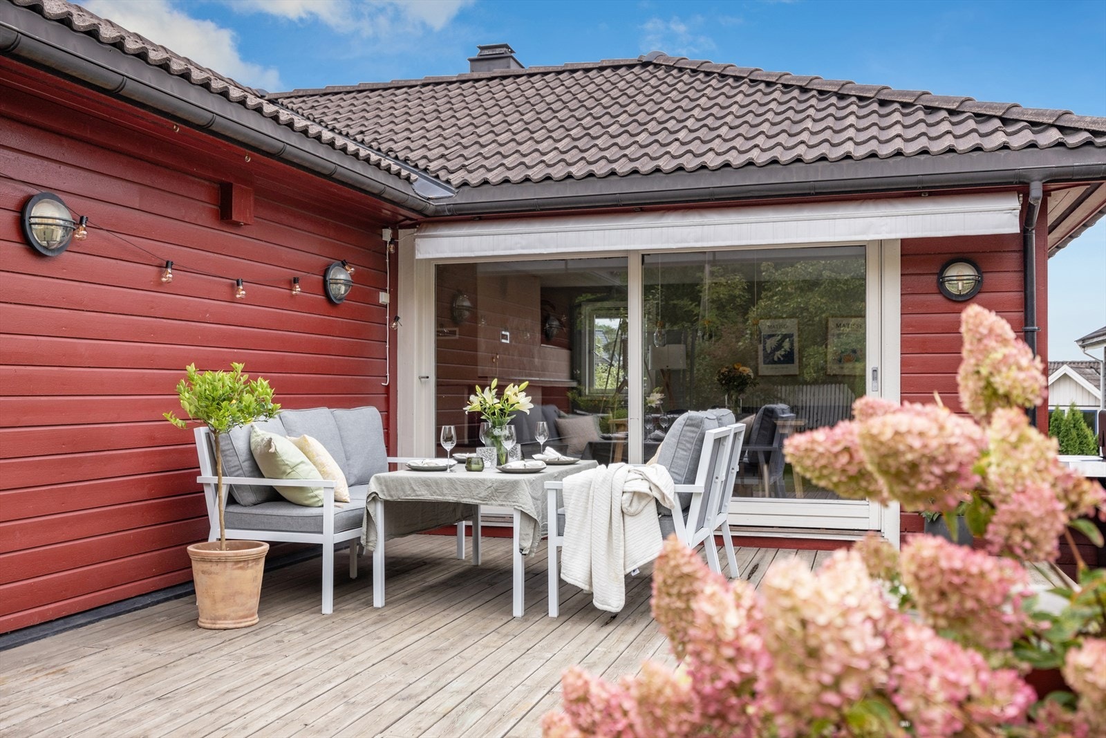 Et innbydende uteområde med god plass til spisegruppe i frodige omgivelser. Galleribilde