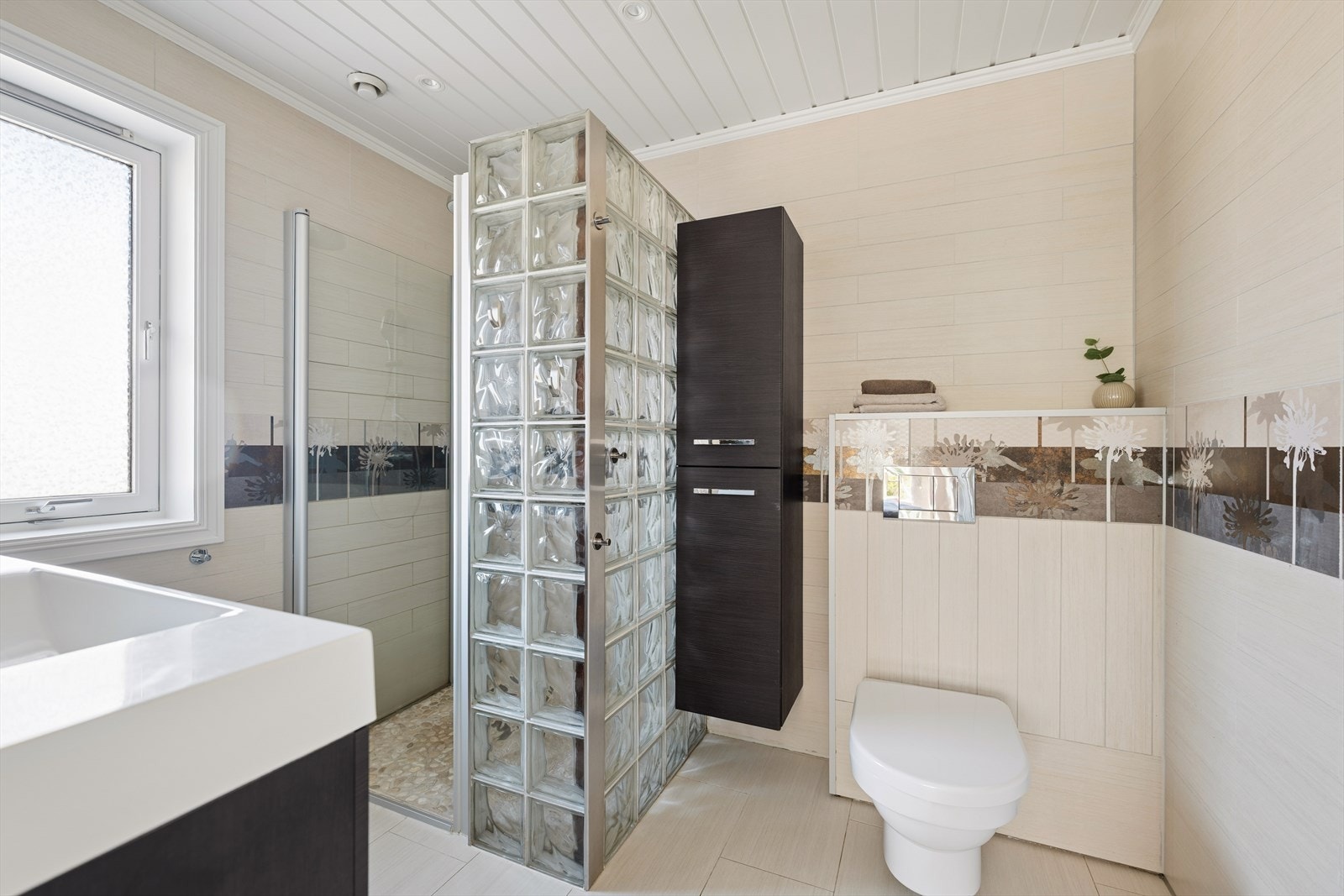 Et lyst og romslig baderom med både dusj og gode oppbevaringsløsninger - perfekt tilpasset familiens behov. Galleribilde