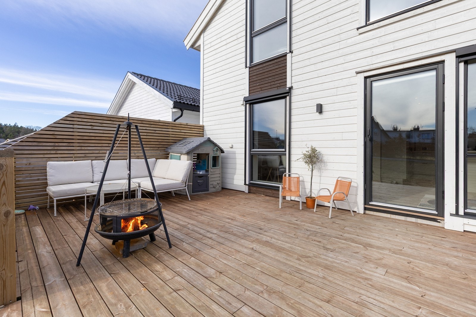 Romslig terrasse med levegg som skiller mot naboeiendom Galleribilde