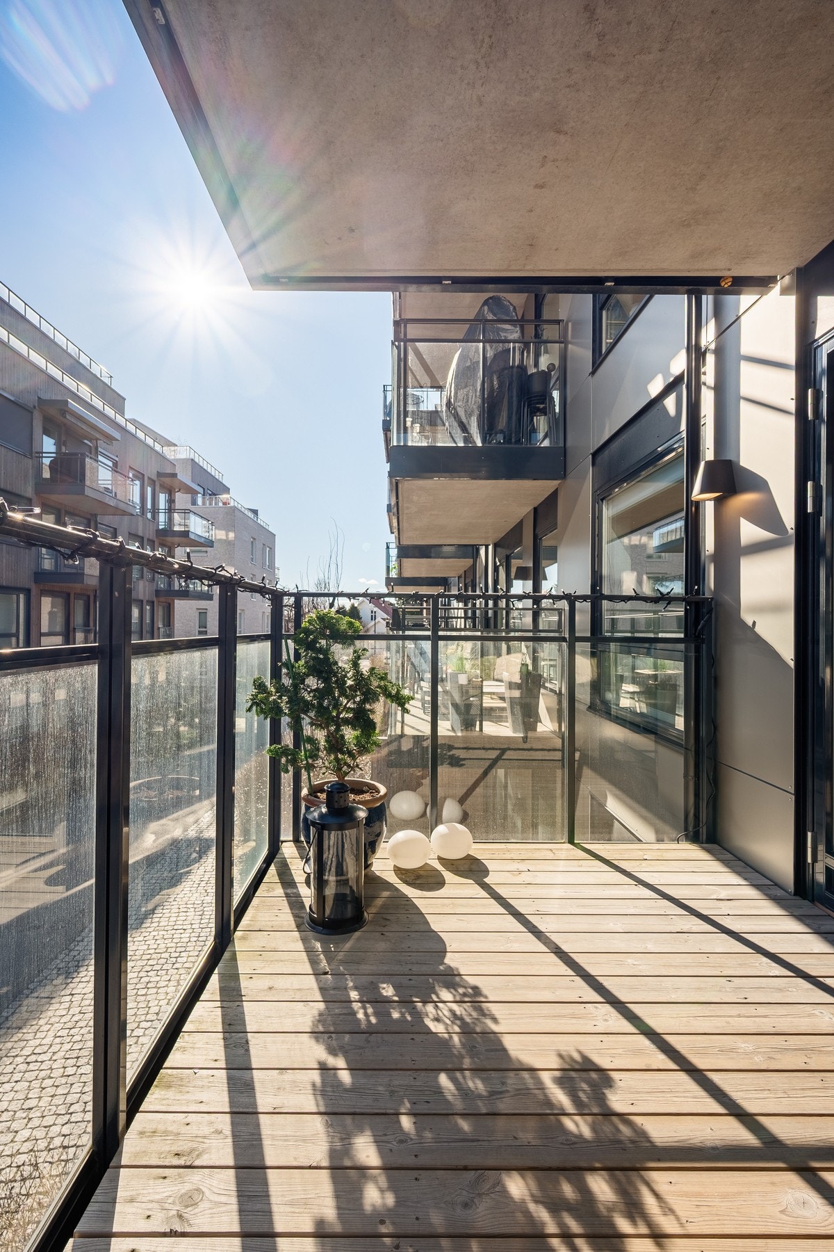 Den nordvestvendte balkongen er oppført i betong med stilfullt tredekke og moderne rekkverk i stål og glass. Galleribilde