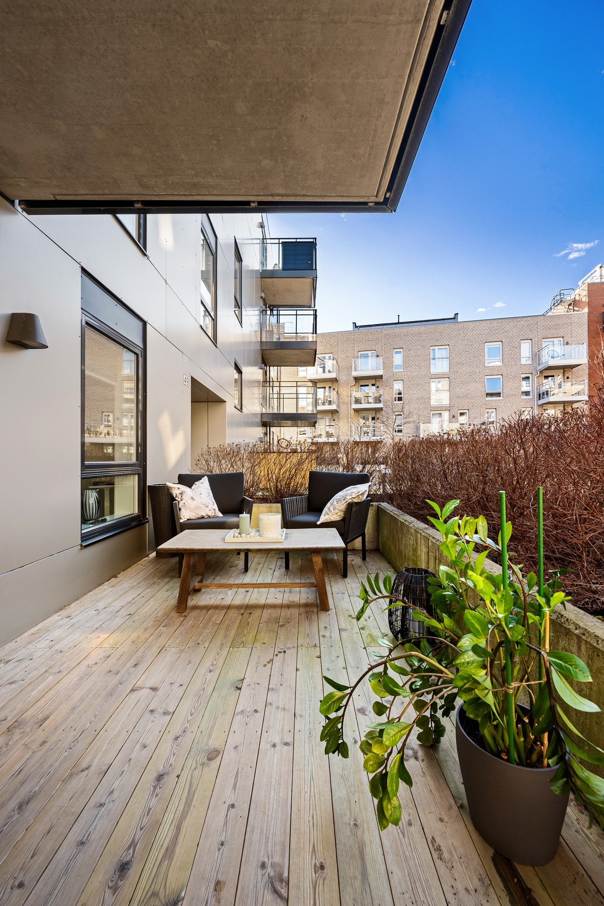 I tillegg finner du en sørøstvendt platting i betong med tredekke, omkranset av betongrekkverk og hekk som gir både skjerming og et grønt preg. Galleribilde