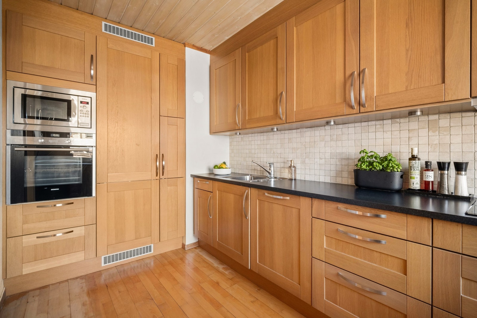 Pent og stilrent kjøkken. Godt med skap- og benkeplass, samt underlimt oppvaskkum og integrert ventilator. Galleribilde